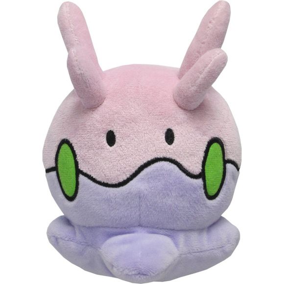 Goomy looks like a light purple, vaguely slug-like pile of goo. The top half of its body is a lighter purple than its bottom half, and the two halves are separated by a squiggly, dark purple outline decorated with five green dots. It has beady eyes, and it has two rows of two horn-like structures on top of its head. Approx. Size: 4"L x 5"W x 5"H